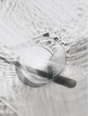 Gouttelettes d'eau cristalline sur flacon de soin, illustrant la pureté et la fraîcheur des produits Derma'Love pour une hydratation naturelle et lumineuse.