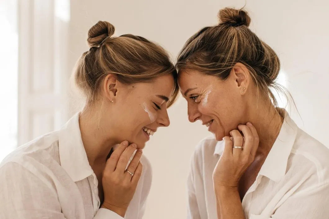 Duo intergénérationnel illustrant la transmission et l'expertise des soins anti-âge Derma'Love, mère et fille complices, symbolisant l'efficacité des solutions de beauté naturelles.