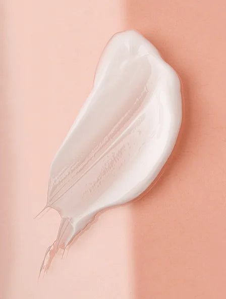Texture onctueuse d'un soin hydratant sur fond rose, révélant la douceur et la précision des produits Derma'Love pour une peau éclatante et naturellement belle.