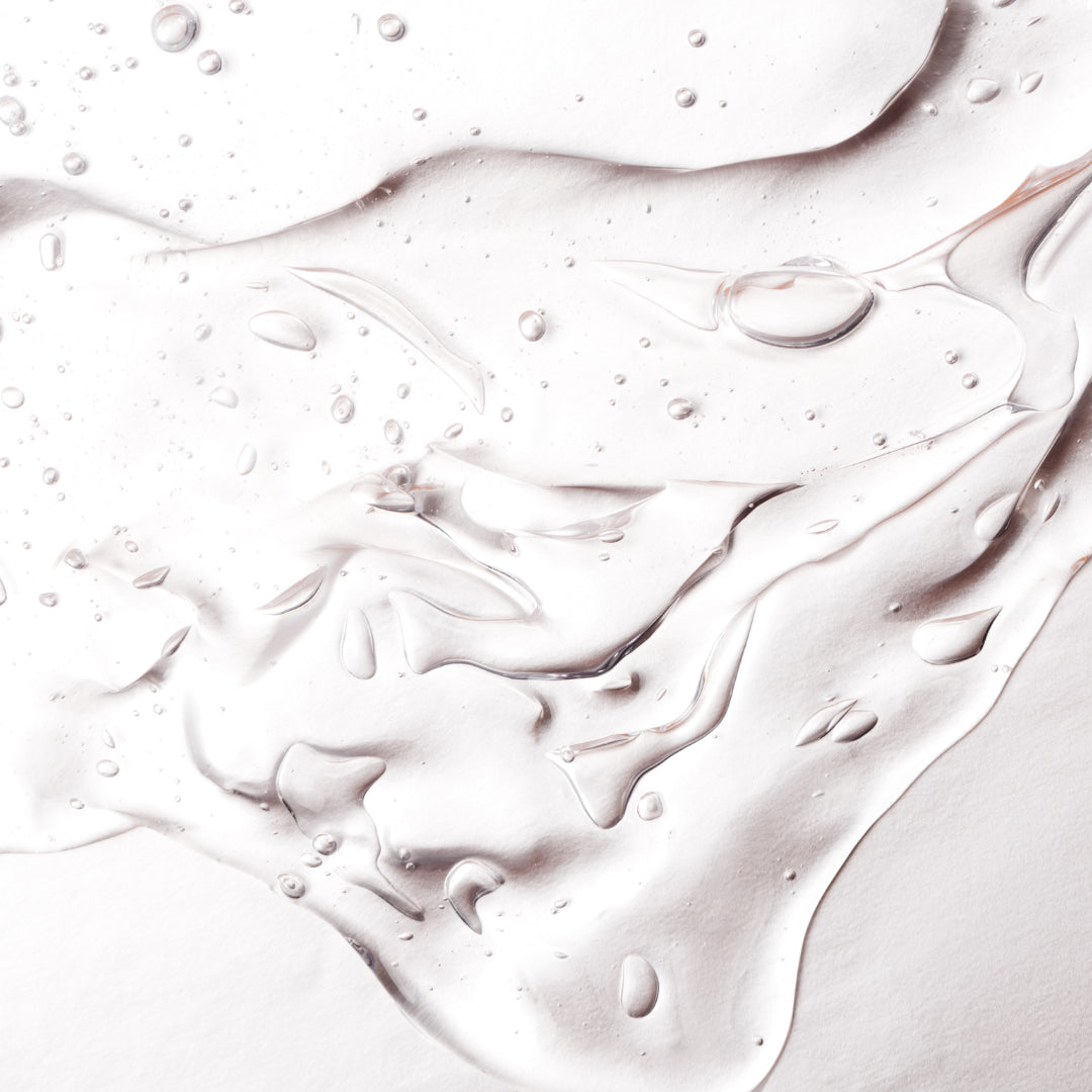 Texture ultra-pure des soins Derma'Love : gel transparent aux reflets nacrés et gouttelettes cristallines, révélant la qualité premium de nos formules bio. La fluidité et la transparence illustrent la pureté de nos actifs naturels certifiés.