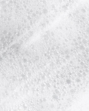 Texture microscopique d'une mousse nettoyante, révélant la finesse et la pureté des soins Derma'Love pour une exfoliation délicate et rafraîchissante.